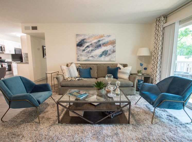 Entertain your family and friends in your spacious living room at Icon Avondale. Couches, chairs, curtains, and light rug on floor.